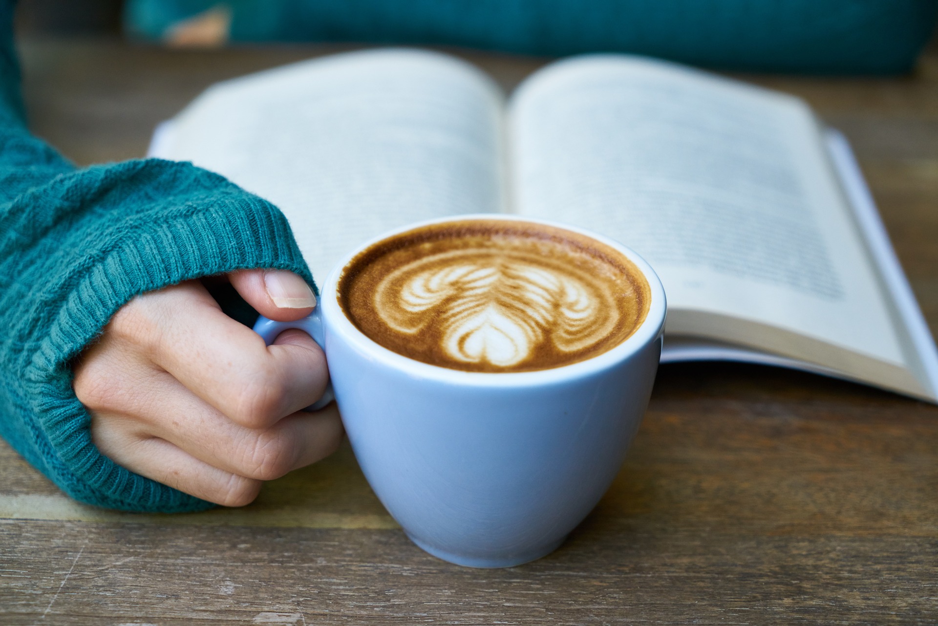 woman reading a book and drinking a coffee