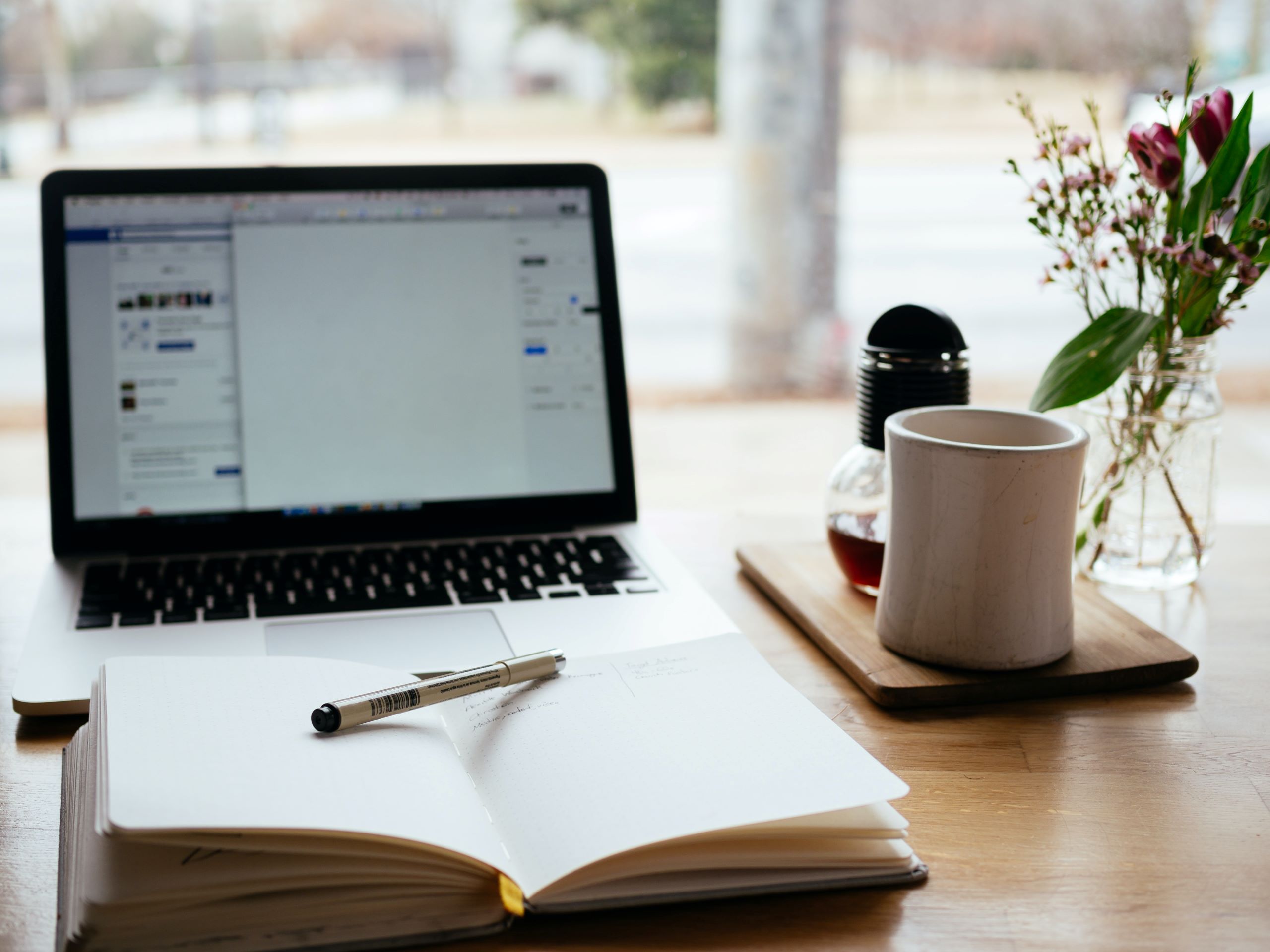 picture of a desk with a notebook with pen