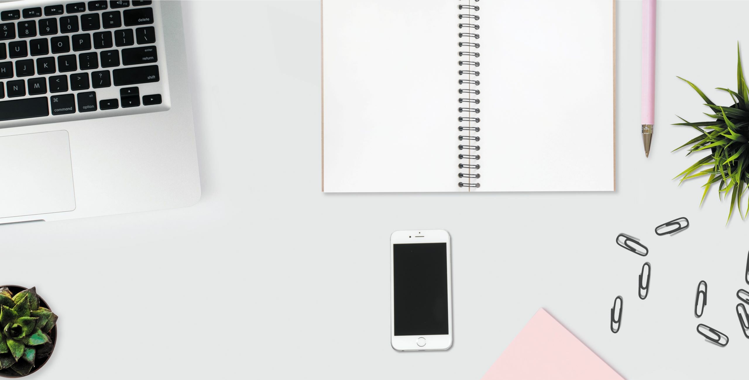 picture of a desk with a laptop, notebook and phone