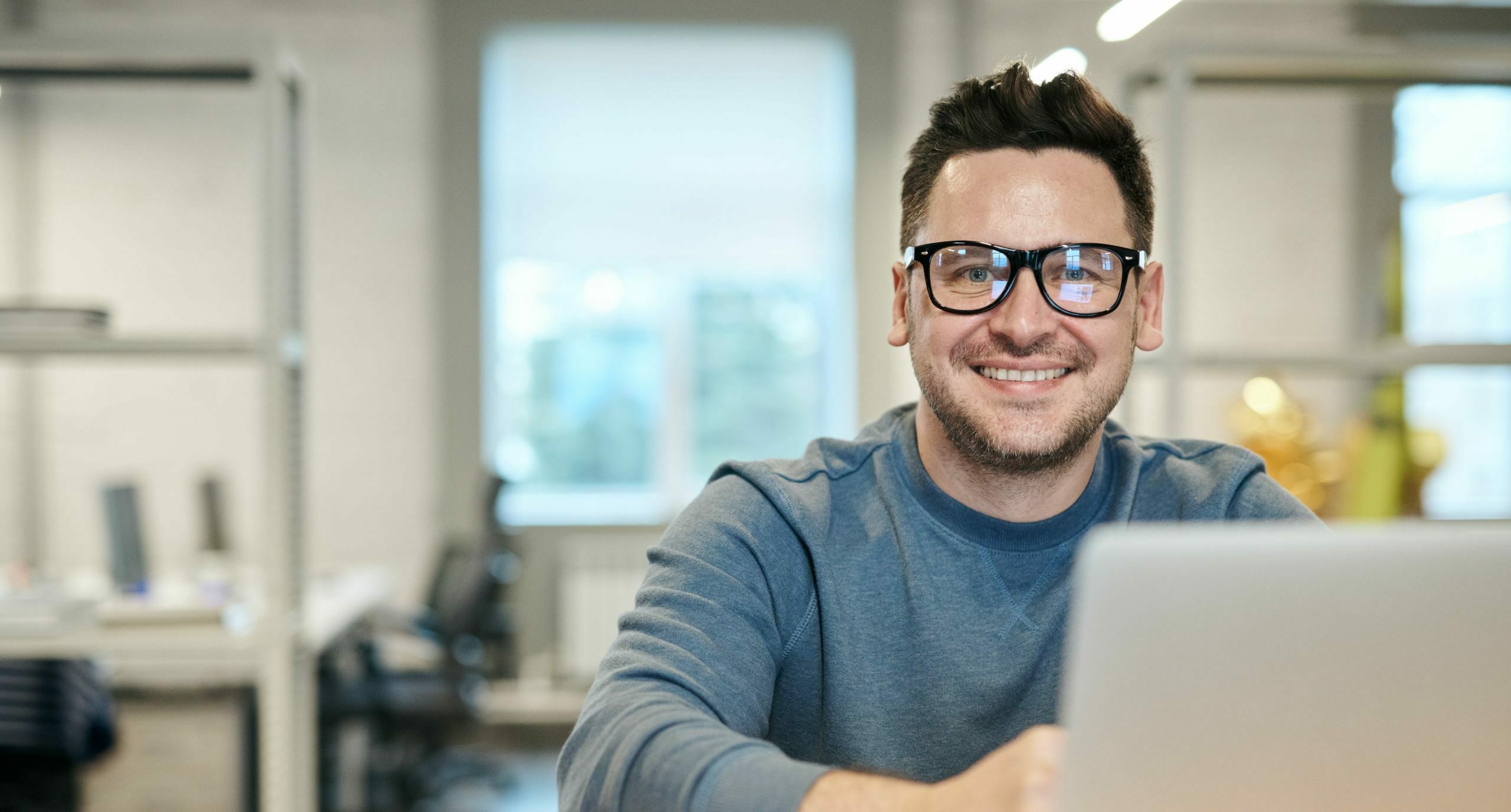 man smiling and working on his laptop