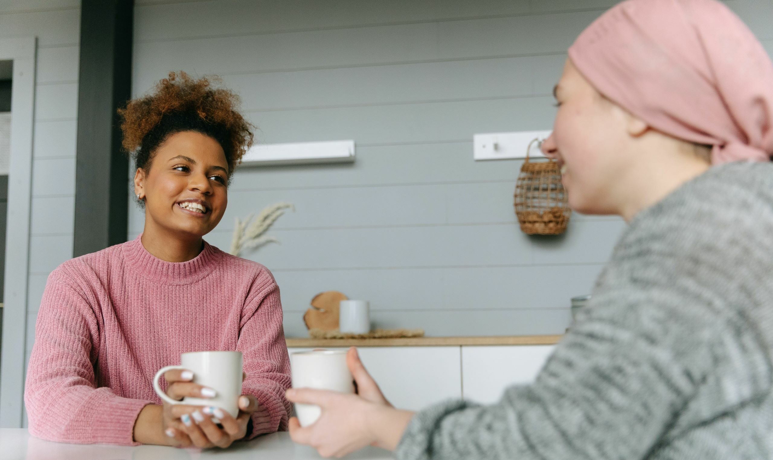 two women talking while having a hot drink