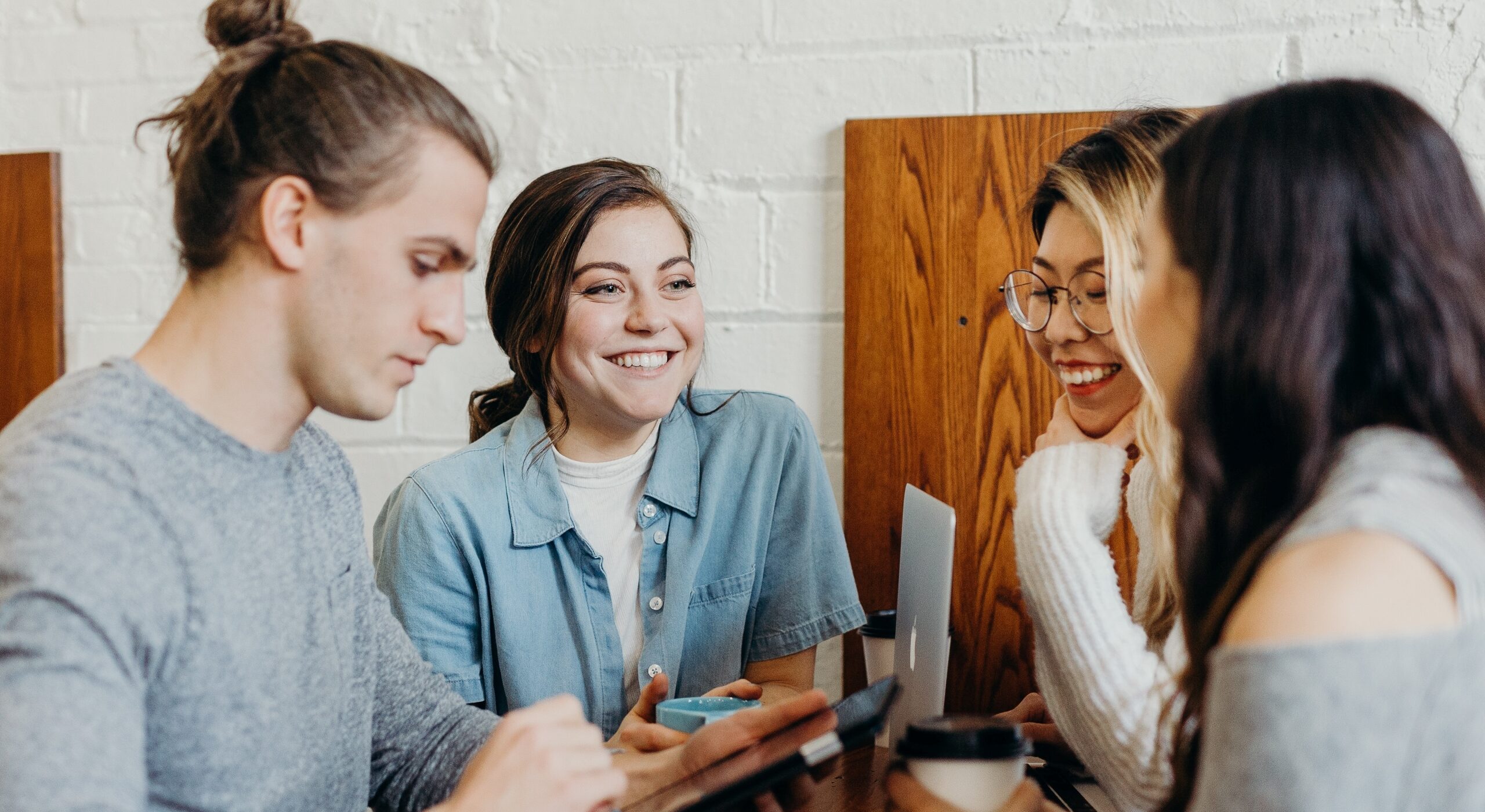 four women talking together in a coffee shop