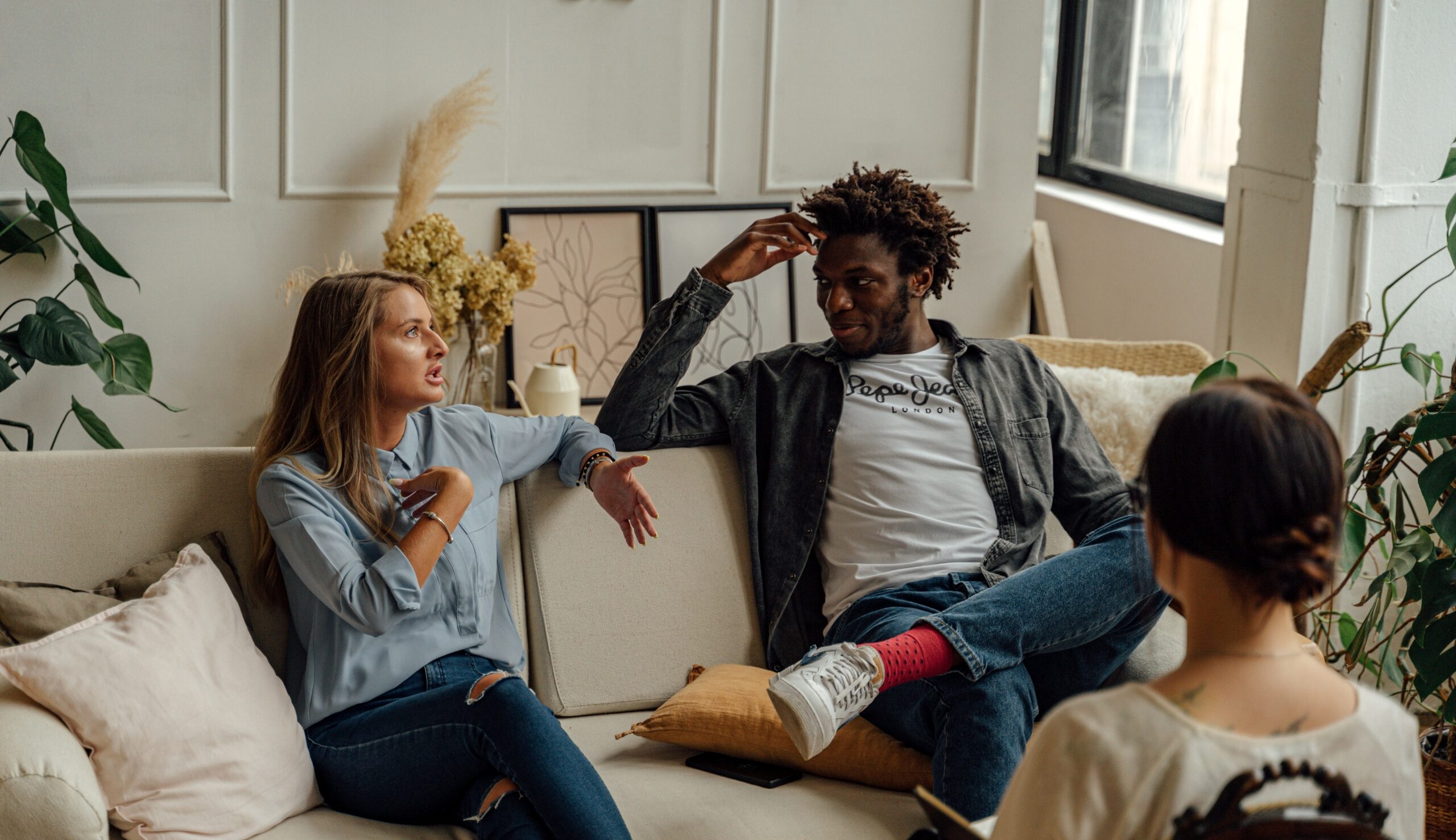 three people in a living space talking