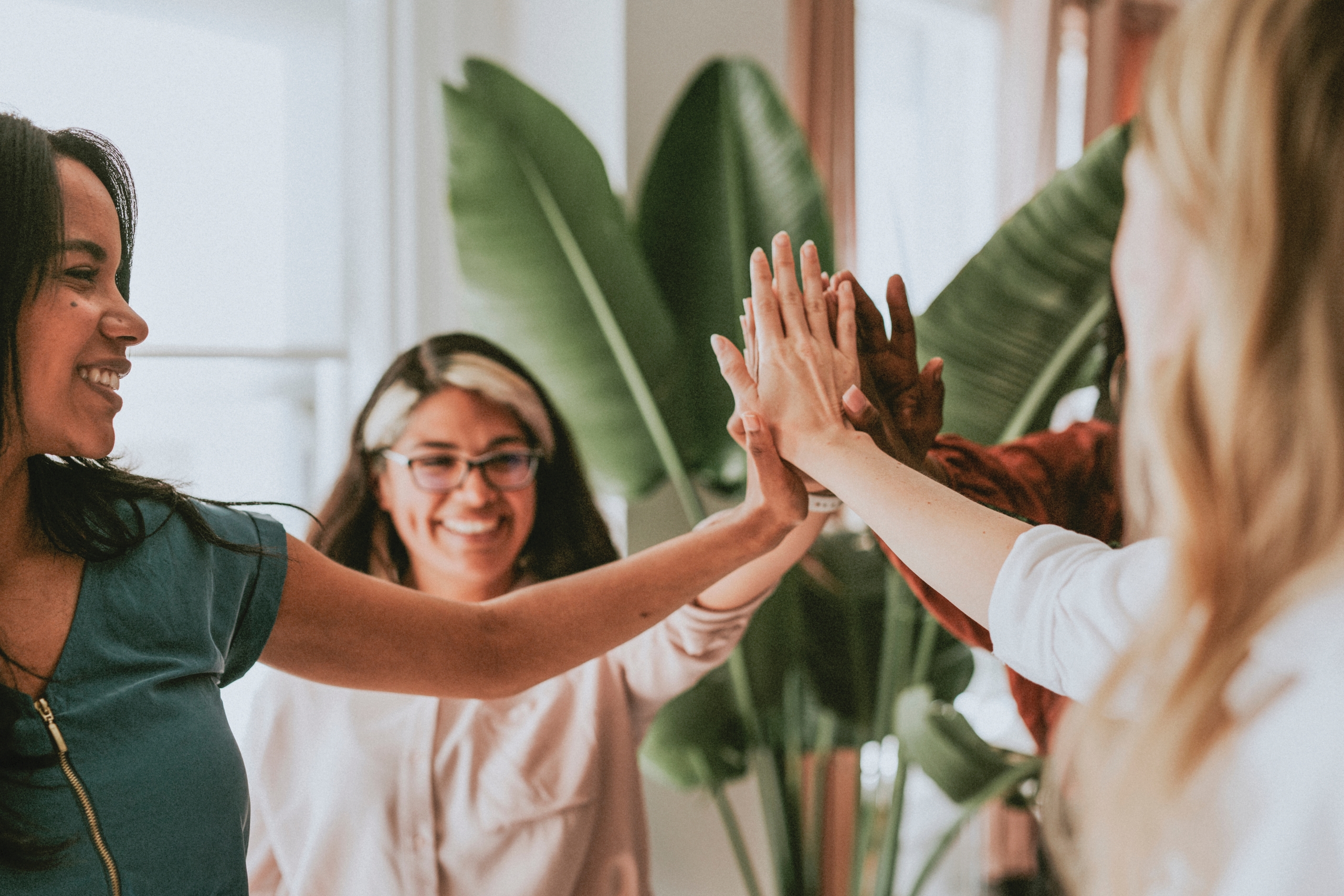 group of people putting their hands in the middle