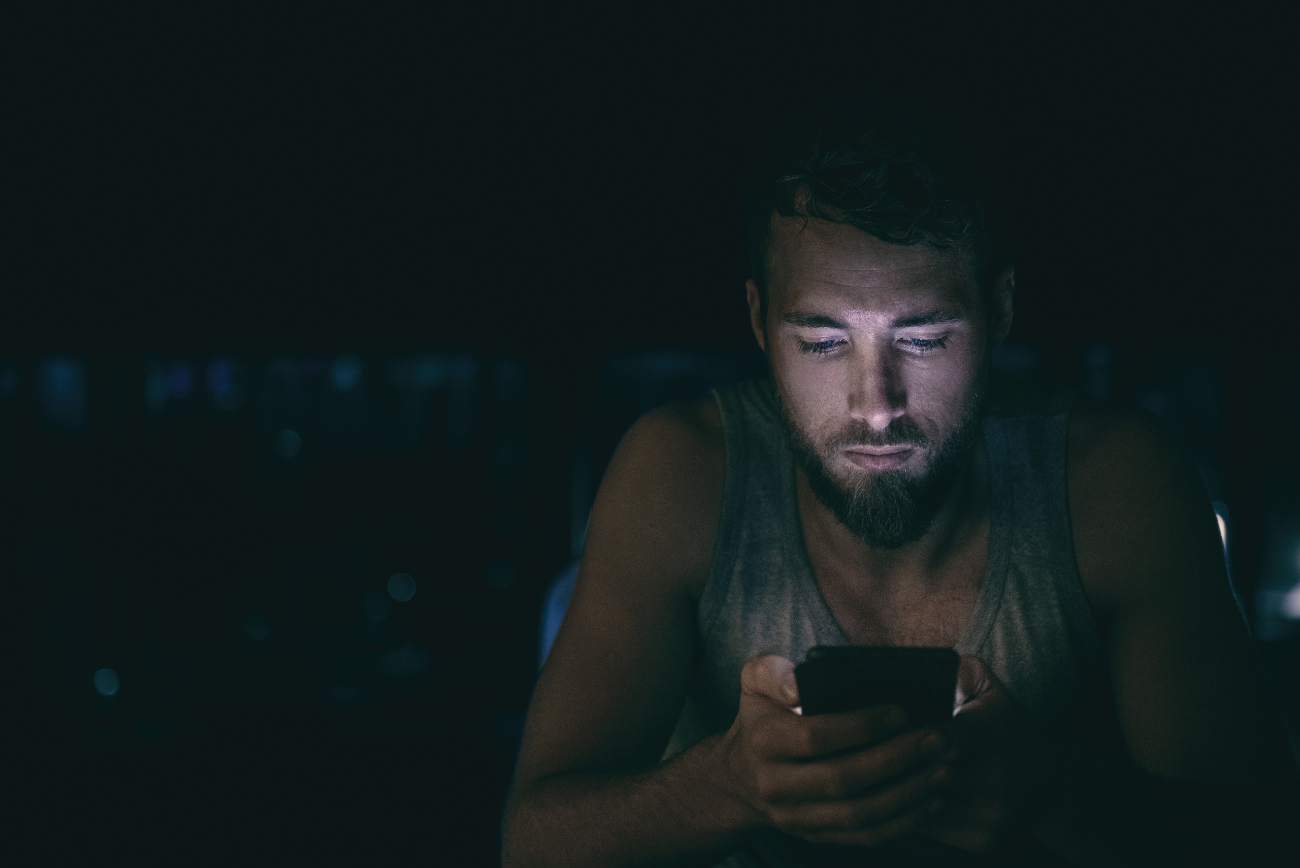 man reading on his phone at night